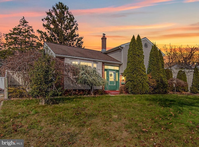 view of front facade featuring a front lawn and a chimney