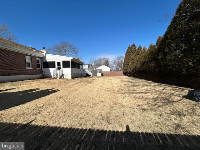 view of yard featuring a sunroom and fence