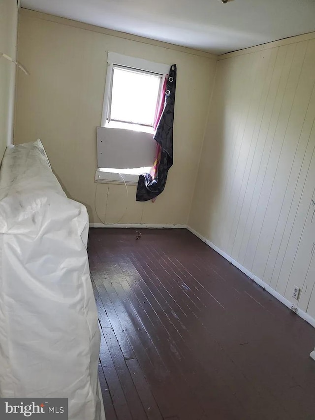 unfurnished bedroom featuring hardwood / wood-style floors and baseboards