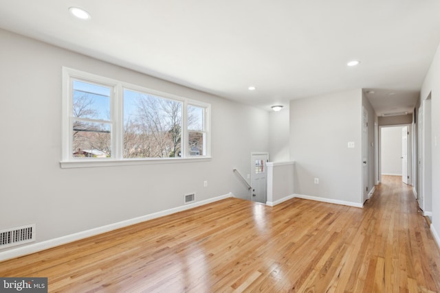 unfurnished room with light wood finished floors, visible vents, recessed lighting, and baseboards