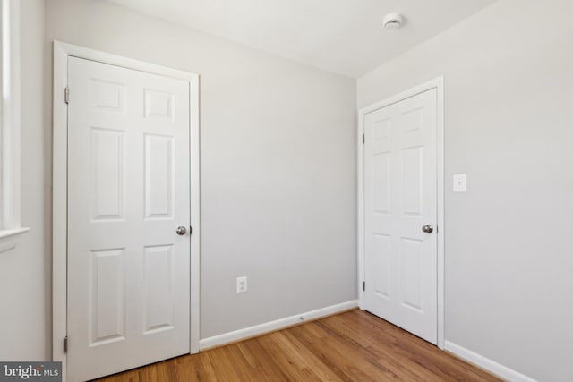 unfurnished bedroom featuring baseboards and light wood-style flooring