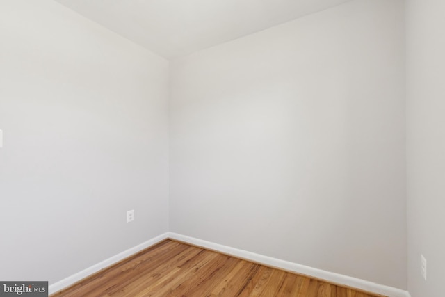 unfurnished room featuring baseboards and light wood-style floors