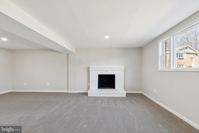 unfurnished living room featuring recessed lighting, a brick fireplace, carpet, and baseboards