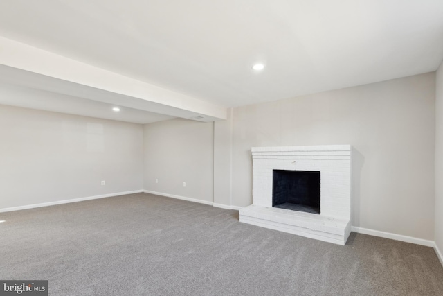 unfurnished living room featuring recessed lighting, a brick fireplace, baseboards, and carpet