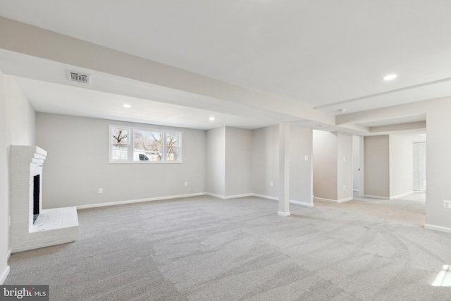 basement featuring carpet, visible vents, baseboards, recessed lighting, and a fireplace