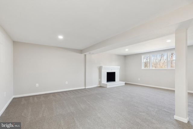 below grade area featuring recessed lighting, a fireplace, baseboards, and carpet