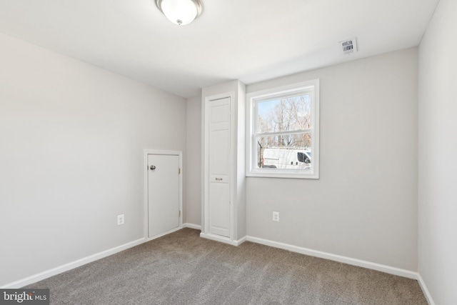 unfurnished bedroom with visible vents, baseboards, and carpet