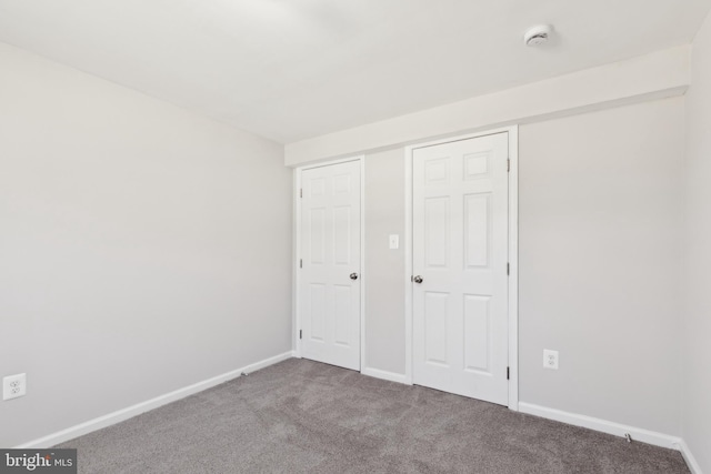 unfurnished bedroom with carpet flooring and baseboards