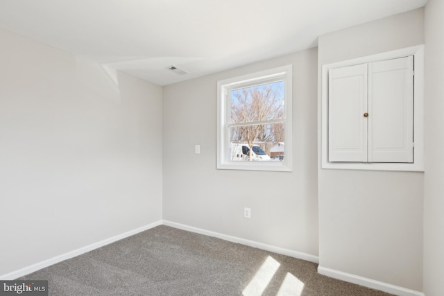 carpeted spare room featuring baseboards