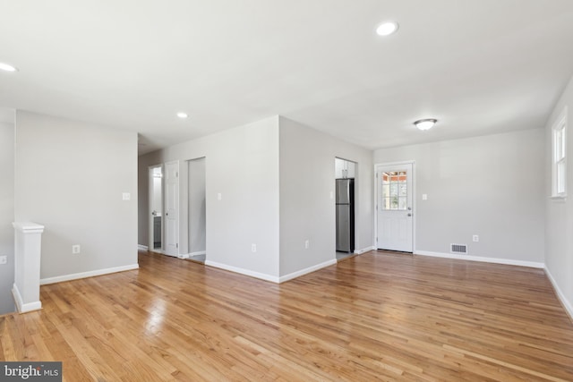 unfurnished living room with visible vents, recessed lighting, light wood-style flooring, and baseboards