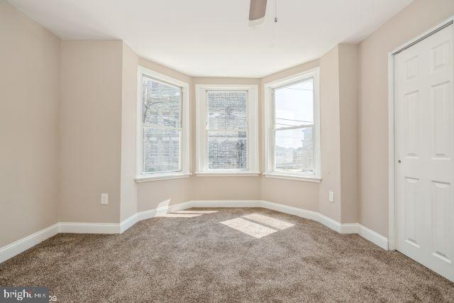 unfurnished room with carpet floors, ceiling fan, and baseboards