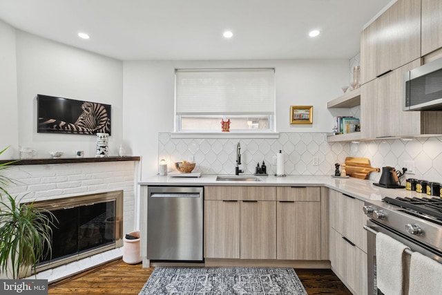 kitchen with dark wood finished floors, stainless steel appliances, light countertops, light brown cabinetry, and a sink