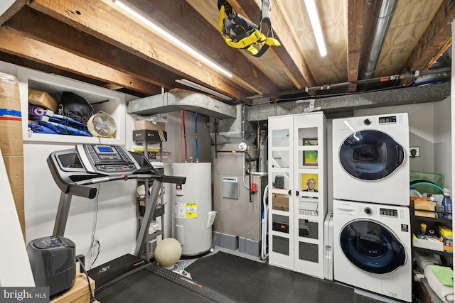 laundry area with stacked washer and clothes dryer, electric water heater, and laundry area