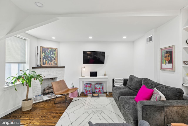 living area featuring baseboards, visible vents, wood finished floors, a fireplace, and recessed lighting