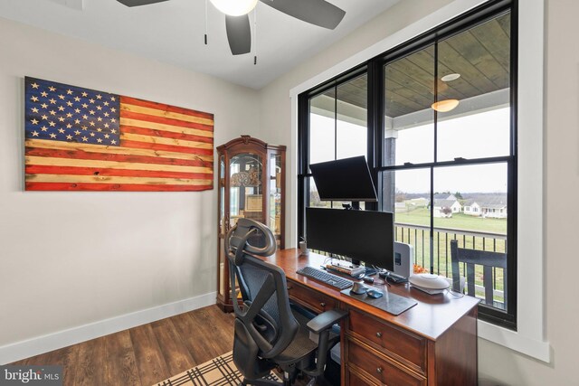 office featuring baseboards, ceiling fan, wood finished floors, and a healthy amount of sunlight