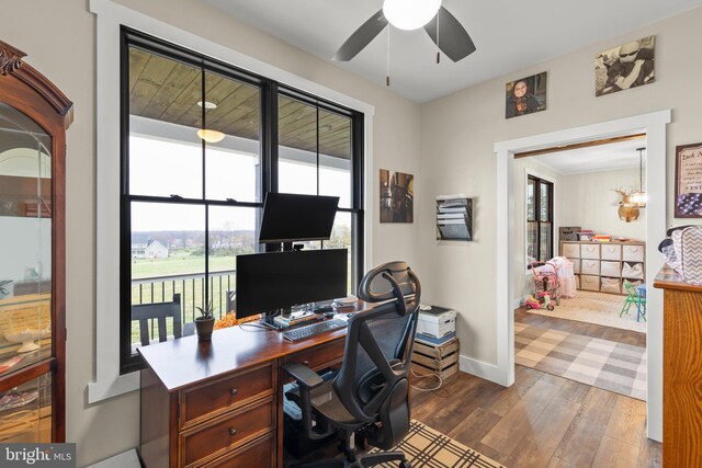 home office with ceiling fan, dark wood finished floors, a wealth of natural light, and baseboards