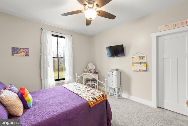 carpeted bedroom with ceiling fan and baseboards