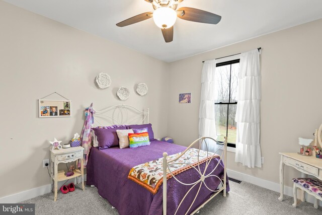 carpeted bedroom with a ceiling fan, visible vents, and baseboards