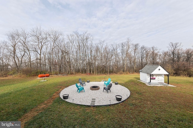 view of yard with an outdoor fire pit, a patio, and an outbuilding