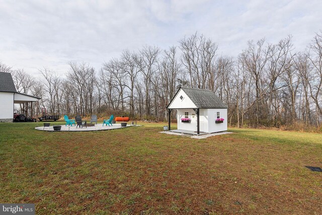 view of yard featuring an outdoor fire pit, a storage unit, a patio, and an outdoor structure