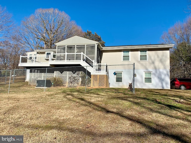 back of property featuring a sunroom, stairway, fence, and a lawn