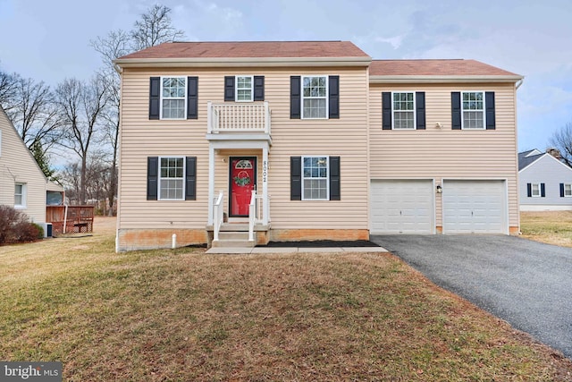 view of front of property with aphalt driveway, a front lawn, and an attached garage