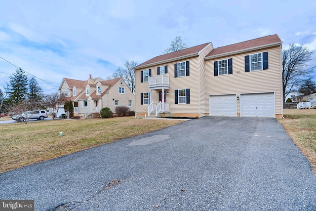 view of front of home featuring aphalt driveway, a front lawn, and an attached garage