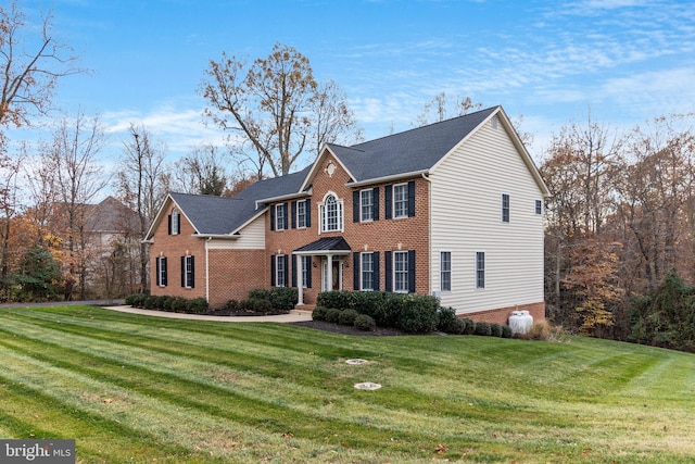 view of front of house with brick siding and a front yard