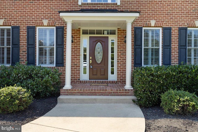 view of exterior entry featuring brick siding