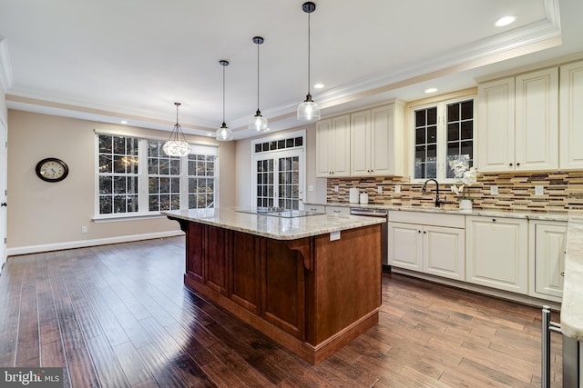 kitchen featuring dark wood finished floors, a raised ceiling, a kitchen island, and black electric stovetop