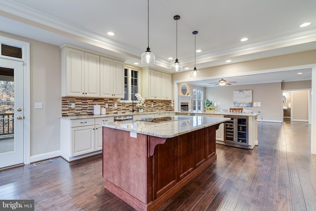 kitchen featuring a peninsula, dark wood-style floors, beverage cooler, and black electric cooktop