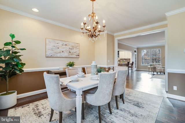 dining space featuring ornamental molding, hardwood / wood-style flooring, and baseboards