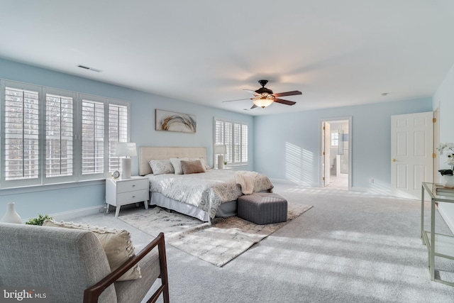 carpeted bedroom featuring connected bathroom, visible vents, ceiling fan, and baseboards