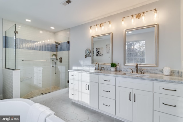 full bath with double vanity, visible vents, a stall shower, a sink, and tile patterned floors