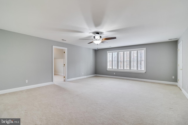 spare room featuring baseboards, a ceiling fan, and light colored carpet