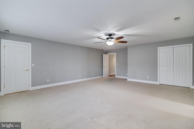 unfurnished bedroom with ceiling fan, carpet floors, visible vents, and baseboards