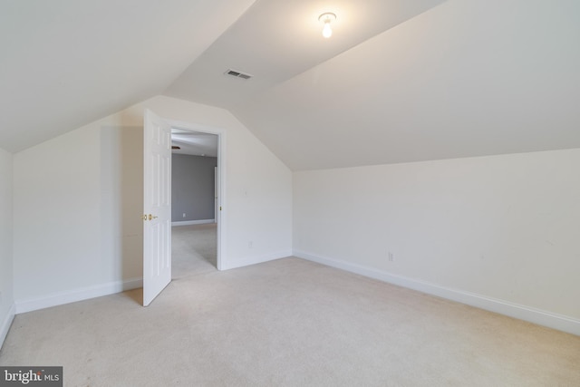 additional living space featuring light colored carpet, visible vents, and baseboards