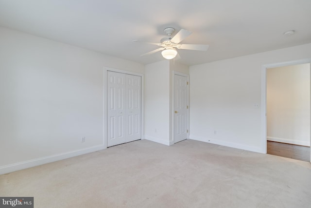 unfurnished bedroom featuring carpet floors, a closet, baseboards, and a ceiling fan