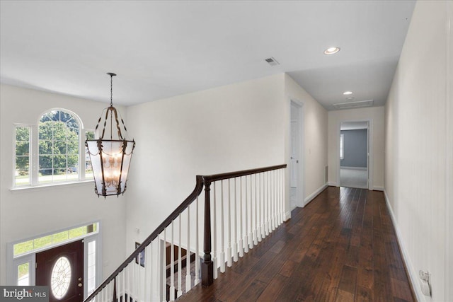 hall featuring a notable chandelier, recessed lighting, visible vents, baseboards, and hardwood / wood-style floors