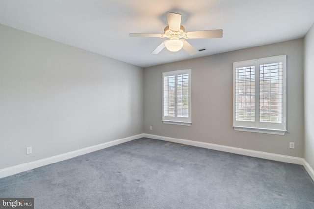 empty room featuring ceiling fan, visible vents, baseboards, and carpet flooring