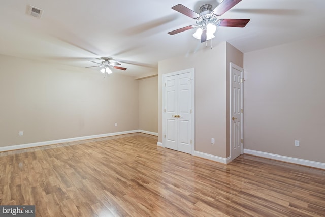 interior space with light wood finished floors, visible vents, baseboards, and a ceiling fan