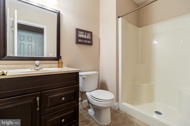 full bath featuring baseboards, toilet, tile patterned floors, vanity, and a walk in shower