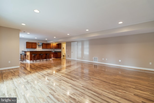 unfurnished living room with recessed lighting, visible vents, light wood-style flooring, and baseboards