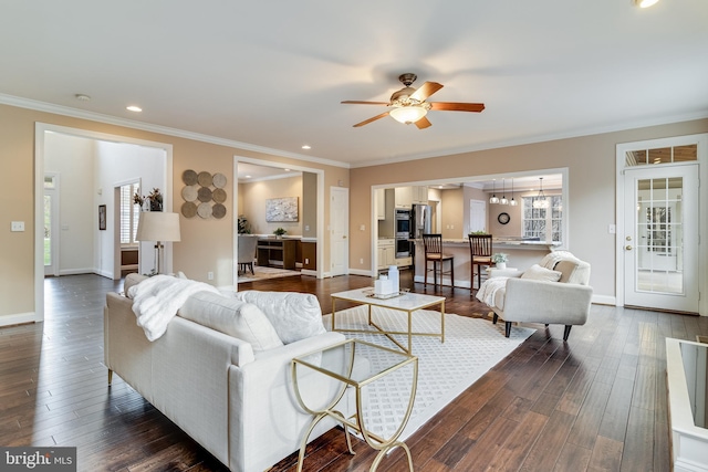 living room featuring dark wood-style floors, ornamental molding, a ceiling fan, and baseboards