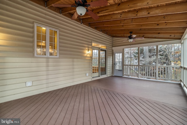 unfurnished sunroom with wood ceiling, a ceiling fan, and beam ceiling