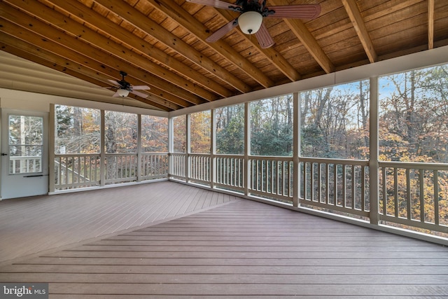 unfurnished sunroom featuring a ceiling fan, wood ceiling, and vaulted ceiling with beams