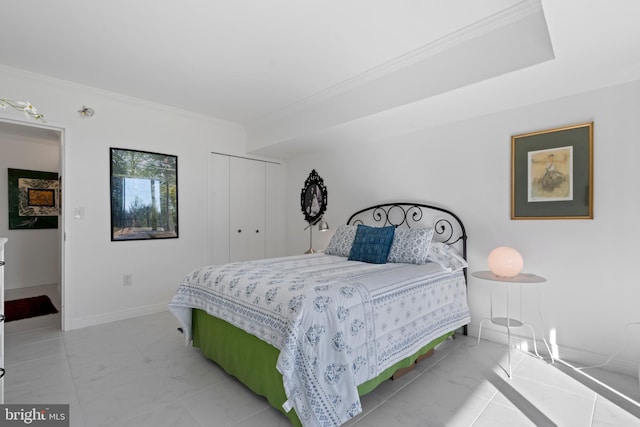 bedroom with marble finish floor, ornamental molding, a closet, and baseboards