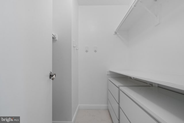 walk in closet with marble finish floor