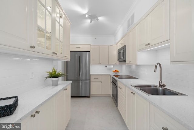 kitchen with ornamental molding, glass insert cabinets, a sink, and black appliances