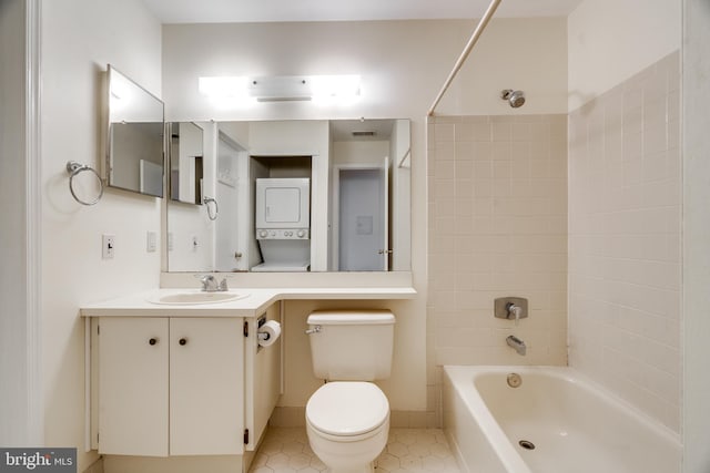 bathroom featuring stacked washer and clothes dryer, shower / bathtub combination, visible vents, toilet, and vanity